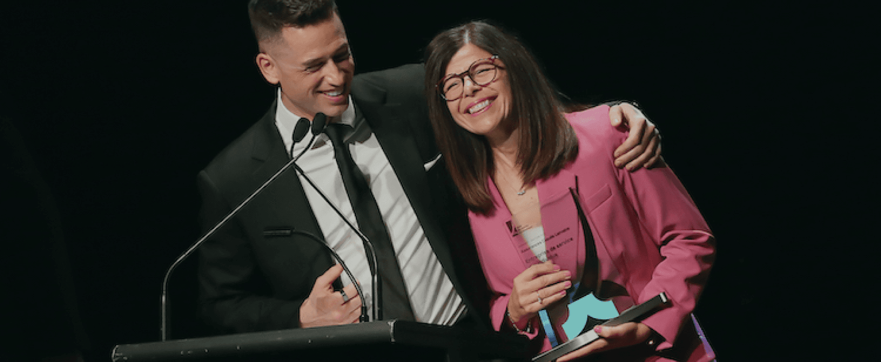 Vincent Lemoine et une femme en tailleur rose